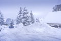 Auron, France 01.01.2021 A harvesting tractor cleans snow in a ski resort on the road in a heavy snowfall. Mountain