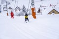 AURON, FRANCE - 01.01.2021: Professional ski instructor and child lifting on the ski drag lift rope to the mountain