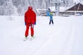 AURON, FRANCE - 01.01.2021: Professional ski instructor and child lifting on the ski drag lift rope to the mountain during