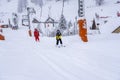 AURON, FRANCE - 01.01.2021: Professional ski instructor and child lifting on the ski drag lift rope to the mountain