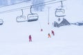 Auron, France 01.01.2021 Snowing on the ski slopes. Empty chair ski lift. Scenic landscape. Children skiers ride in the