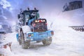 Auron, France 01.01.2021 Tractor removing snow from large snowbanks next to road on a ski resort.