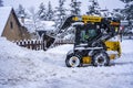 Auron, France 01.01.2021 Wheel loader machine removing snow on a ski resort. Clearing the road from snow