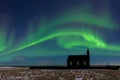 Aurora borealis above the church in Iceland. Green northern lights. Starry sky with polar lights. Royalty Free Stock Photo
