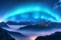 Aurora borealis above mountains in fog at night Royalty Free Stock Photo