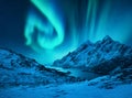 Aurora borealis above the snow covered mountains