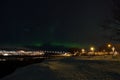 Aurora borealis dancing over whale island mountain and bridge in cold winter