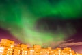 Aurora borealis green starry night over the city and houses Royalty Free Stock Photo