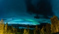 Aurora Borealis and heavy clouds over Norwegian mountains around Rossvatnet Lake, Northern Norway. Late summer night Royalty Free Stock Photo