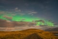 Aurora Borealis in Iceland northern lights bright beams over clouds during full moon Royalty Free Stock Photo