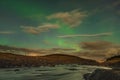 Aurora Borealis in Iceland northern lights bright beams rising in green beams reflecting in natural river Royalty Free Stock Photo