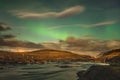 Aurora Borealis in Iceland northern lights bright beams rising in green beams reflecting in natural river during full moon Royalty Free Stock Photo