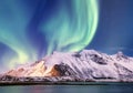 Aurora borealis on the Lofoten islands, Norway. Green northern lights above mountains. Night sky with polar lights. Night winter l Royalty Free Stock Photo