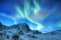 Aurora borealis on the Lofoten islands, Norway. Green northern lights above mountains. Night sky with polar lights. Night winter l Royalty Free Stock Photo