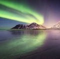 Aurora borealis on the Lofoten islands, Norway. Green northern lights above mountains. Night sky with polar lights. Night winter l Royalty Free Stock Photo