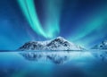 Aurora Borealis, Lofoten islands, Norway. Northen lights, mountains and reflection on the water. Winter landscape during polar lig