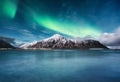 Aurora Borealis, Lofoten islands, Norway. Northen lights, mountains and reflection on the water. Winter landscape during polar lig