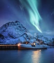 Aurora Borealis, Lofoten islands, Norway. Nothen light, mountains and boat. Winter landscape at the night time.
