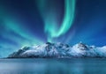 Aurora Borealis, Lofoten islands, Norway. Nothen light, mountains and frozen ocean. Winter landscape at the night time. Royalty Free Stock Photo