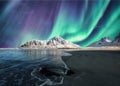 Aurora Borealis, Northern Lights Above on snowy mountain in Skagsanden Beach at Lofoten Islands