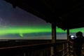 Aurora borealis, The Northern lights at the lake Usma and forest, Latvia. Wooden watching tower. Aerial view. A man is Royalty Free Stock Photo