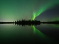 Aurora borealis over lake with island of trees