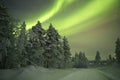 Aurora borealis over a track through winter landscape, Finnish L Royalty Free Stock Photo