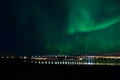 Aurora borealis over tromso city island, fjord and snowy mountain Royalty Free Stock Photo