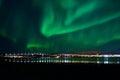 Aurora borealis over tromso city island, fjord and snowy mountain Royalty Free Stock Photo