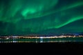 Aurora borealis over tromso city island, fjord and snowy mountain Royalty Free Stock Photo