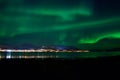 Aurora borealis over tromso city island, fjord and snowy mountain Royalty Free Stock Photo