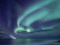 Aurora Borealis, Senja Islands, Norway. Stars, moving clouds and northern light. Mountains and ocean.. Night landscape. Royalty Free Stock Photo