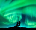 Aurora borealis and silhouette of a man and woman