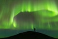 Aurora borealis and silhouette of standing man. Jokulsarlon, Iceland. Aurora and happy man. Sky with stars and green polar lights. Royalty Free Stock Photo