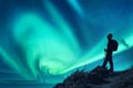 Aurora borealis and silhouette of a woman with backpack at night