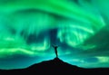 Aurora borealis and silhouette of a woman with raised up arms Royalty Free Stock Photo