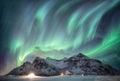 Aurora borealis with starry over snow mountain range with illumination house in Flakstad, Lofoten islands, Norway Royalty Free Stock Photo