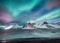 Aurora Borealis. Stars and northern light. Mountains and ocean. Night landscape. Long exposure shot. Senja island, Norway. Royalty Free Stock Photo