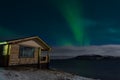 Aurora and a small wooden house