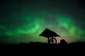 Aurora in the starry sky above the well in the tundra Royalty Free Stock Photo