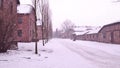 Auschwitz Birkenau, German Nazi concentration and extermination camp. Barracks in falling snow Royalty Free Stock Photo