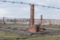 Auschwitz II Birkenau, ruins of barracks at Birkenau. Stoves and chimneys are all that remains of old wooden concentration camp Royalty Free Stock Photo