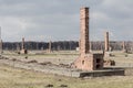 Auschwitz II Birkenau, ruins of barracks at Birkenau. Stoves and chimneys are all that remains of old wooden concentration camp Royalty Free Stock Photo