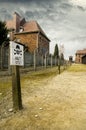 AUSCHWITZ, POLAND - March 30 2012: Sign with reading Stop in German and Polish in front of wired fence in Birkenau