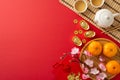 Top view tea ceremony, bamboo mat, sycee, Hong Bao, dragon charm wall hanging, fruits, sakura on red backdrop