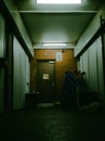 Austere hallway with a closed door, illuminated by a single ceiling light