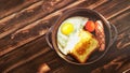 Austere and modest Breakfast. Scrambled eggs, toast and fried sausage in a cramped clay plate on an old wooden table. Royalty Free Stock Photo