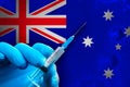 Australia Covid-19 Vaccination Campaign. Hand in a blue rubber glove holds a syringe with covid-19 virus vaccine in front of Royalty Free Stock Photo