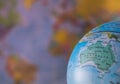 Australiamap on a globe with earth map in the background. Royalty Free Stock Photo