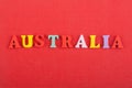 AUSTRALIA word on red background composed from colorful abc alphabet block wooden letters, copy space for ad text. Learning Royalty Free Stock Photo
